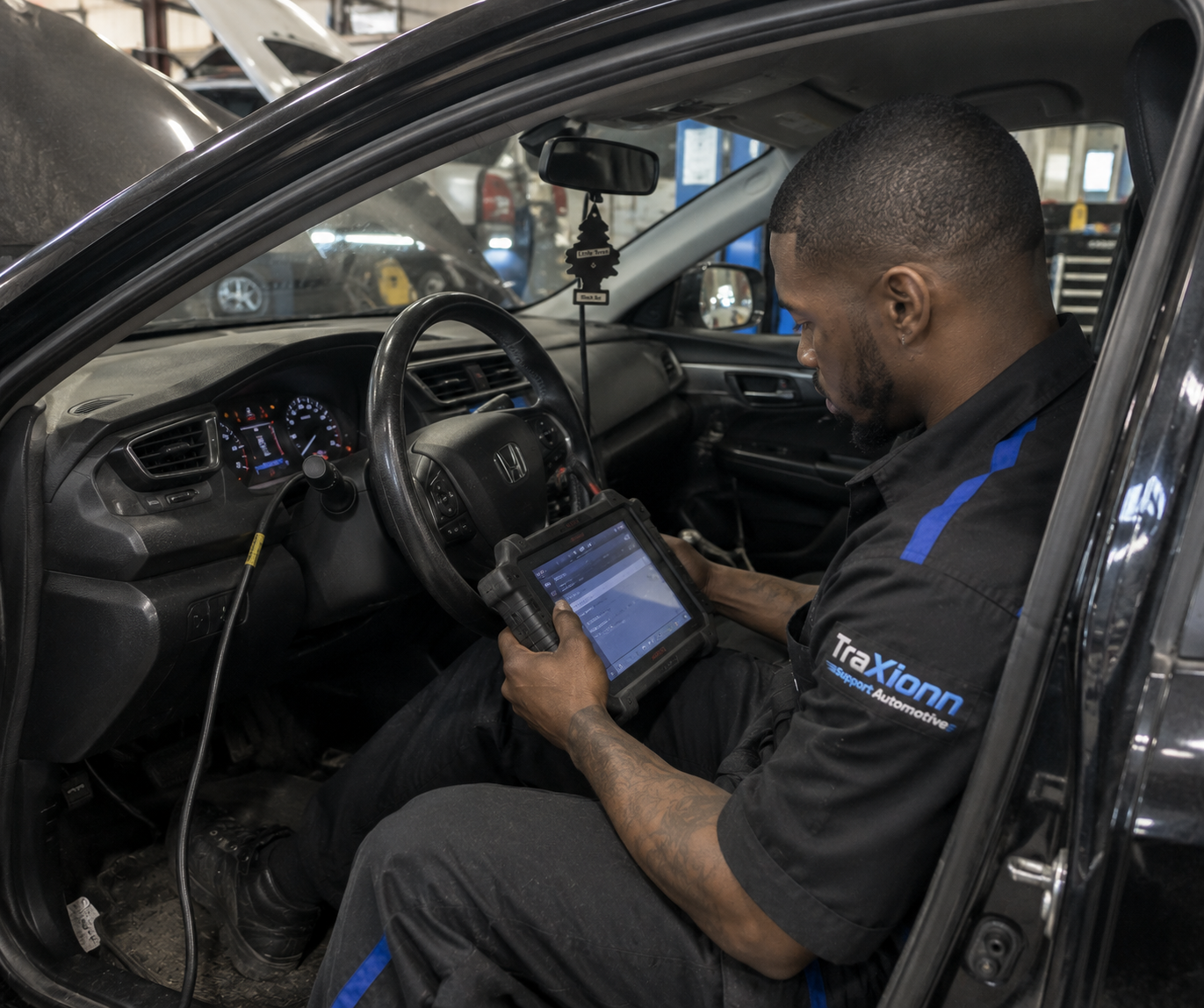 Traxionn technician performing vehicle diagnostics